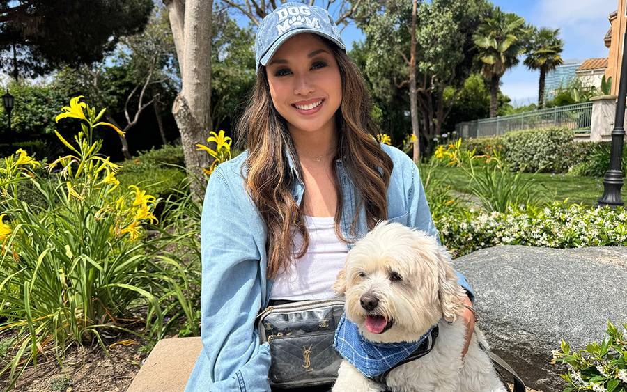 An Asian woman happily sits with her small white dog, representing an ABC 10 News Scripps Health Cancer Survivors Day story.