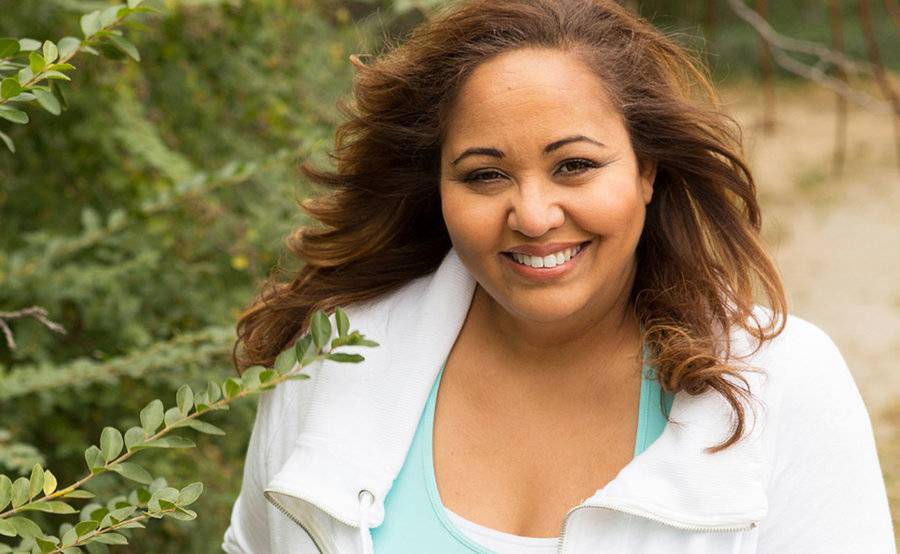 A woman smiles outdoors on a walking trail, representing the active lifestyle that people often enjoy after bariatric surgery.