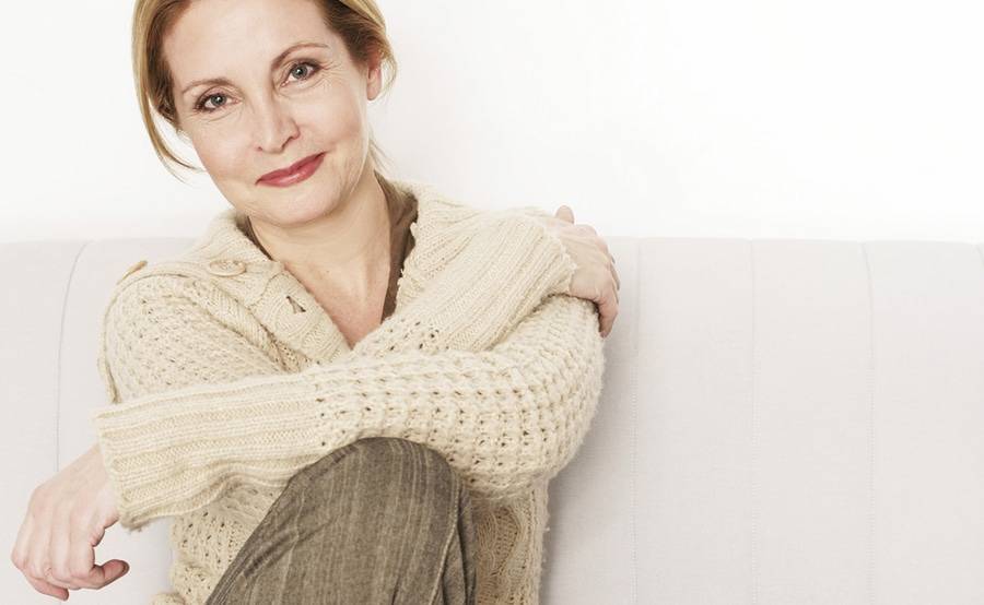 A smiling middle-aged woman represents the empowerment that comes with understanding your breast cancer diagnosis.