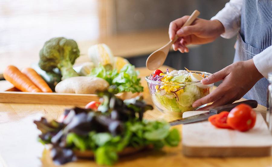 A person makes a fresh salad for nutrition counseling for cancer offered at Scripps Cancer Center.