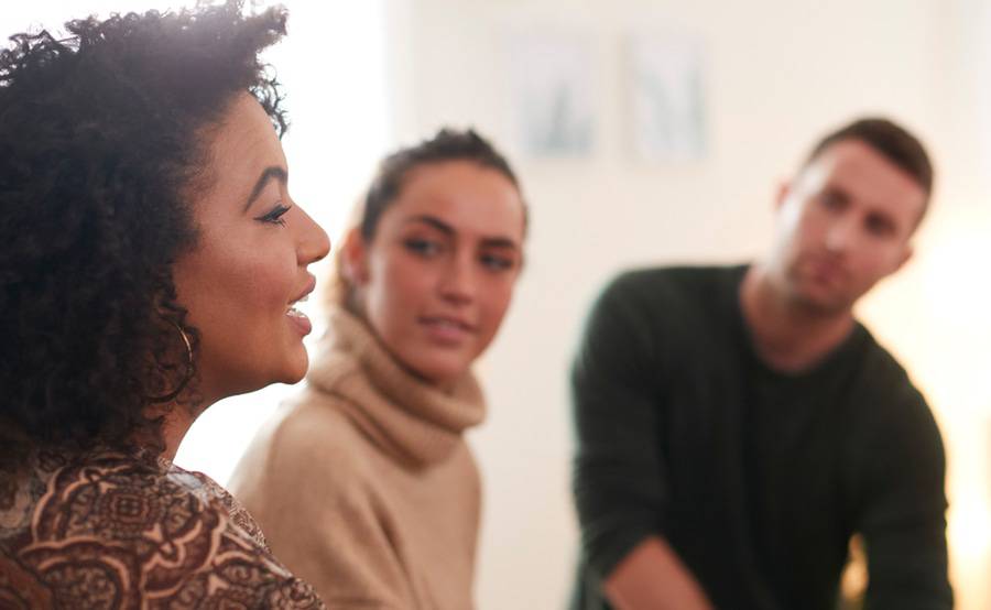 A black woman talks to a white couple about cancer, representing the cancer patient support services at Scripps.