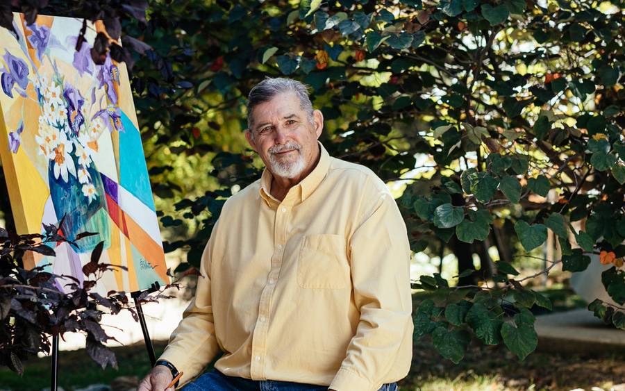 Former NFL pro, Ed White, wears a yellow oxford shirt and paints, grateful for his TAVR treatment at Scripps.
