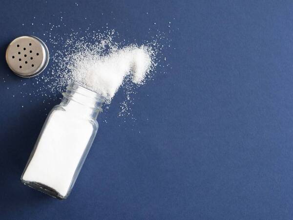 A bottle of salt spilling. Too much salt is not good for your health.