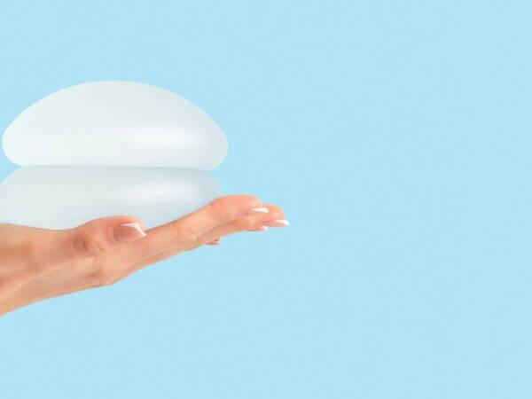 A woman holds breast implants, illustration for mammograms and breast implants.
