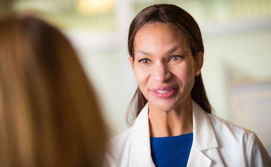 Dr. Rio Dickens-Celestin, MD, Scripps Clinic Internal Medicine physician smiling while discussing treatment with a patient.