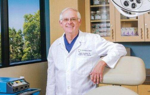 Hubert Greenway, MD, stands in a doctor's office after receiving a major skin cancer award.