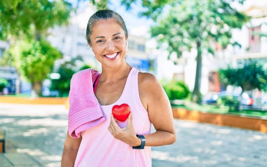 An older woman holds heart figure to symbolize integrative heart care.