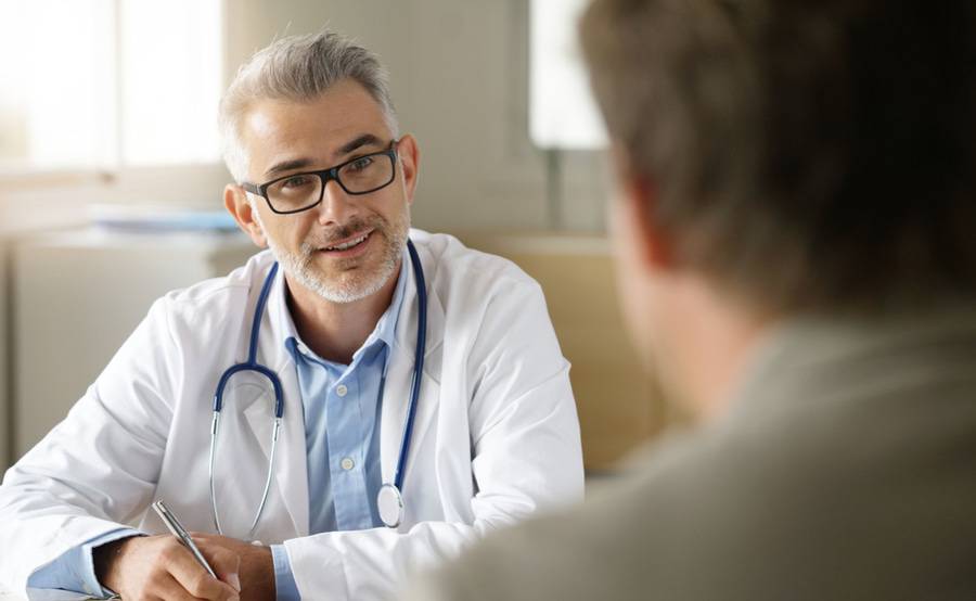 A doctor talks with his patient in an office, representing the care provided at Scripp using fluoroscopy.