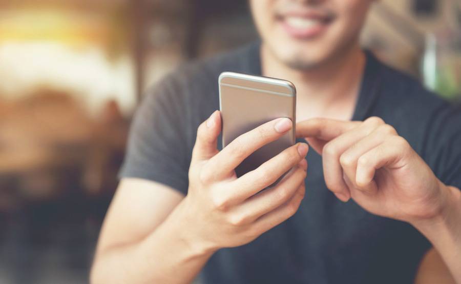 A man holds his mobile phone out, while searching for information online.