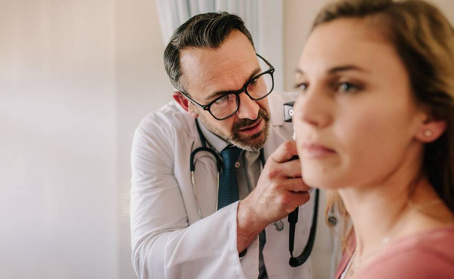 A female patient undergoes a hearing exam.