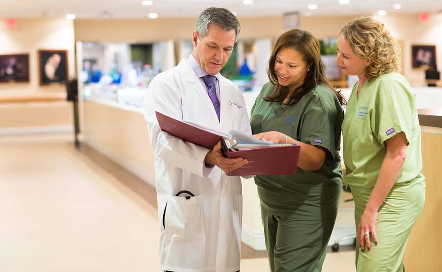 Three Scripps Health kidney transplant experts having a discussion in a medical facility waiting area.