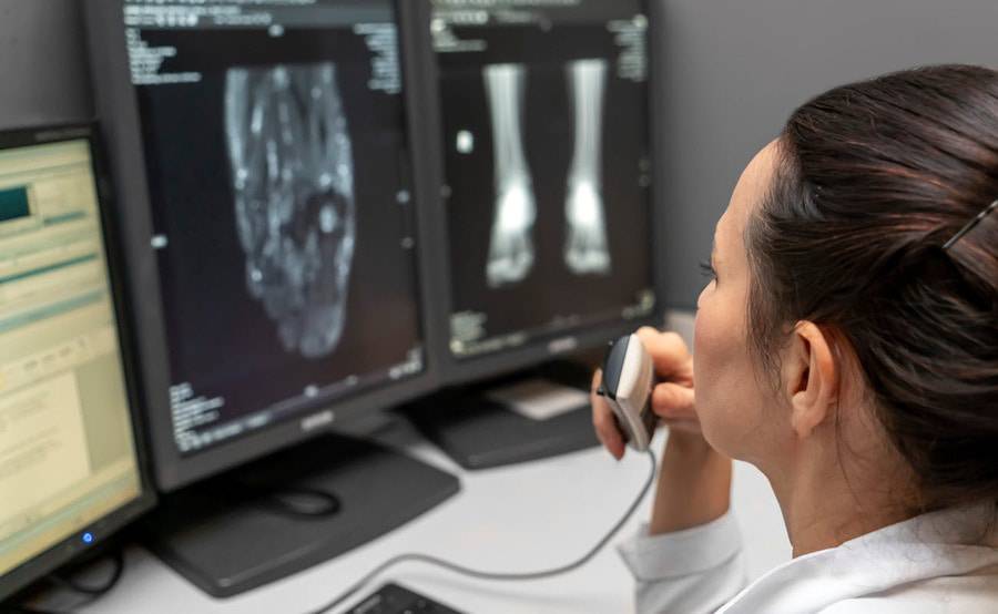 An imaging technician evaluates digital X-rays on a computer.