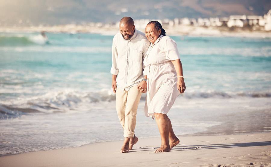 A mature couple walks down the beach, representing the successful management of kidney disease by Scripps nephrologists.