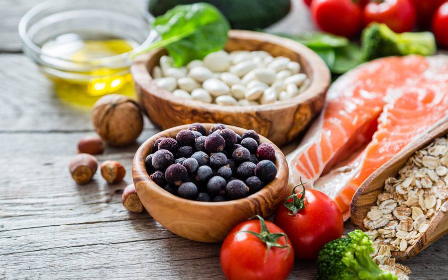 Salmon, tomatos, nuts, and berries on a table