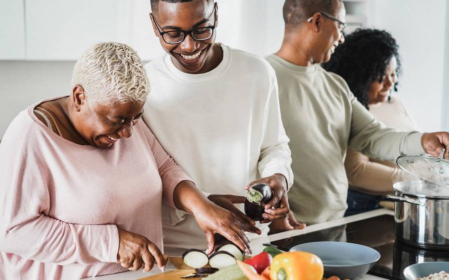 Family in kitchen cutting up produce
