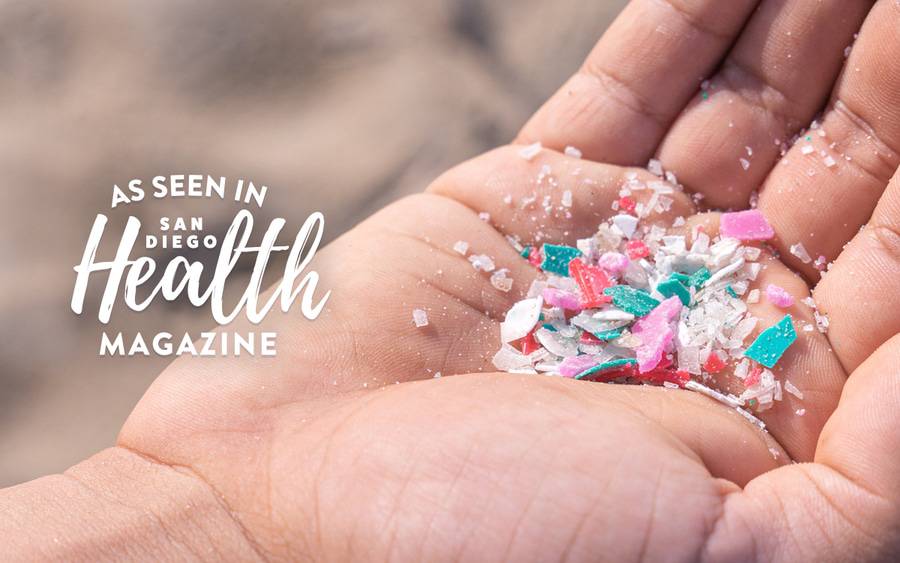 Microplastic pieces in the palm of a person's hand. San Diego Health Magazine