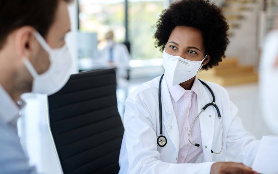 A patient and physician conversing while at an appointment.