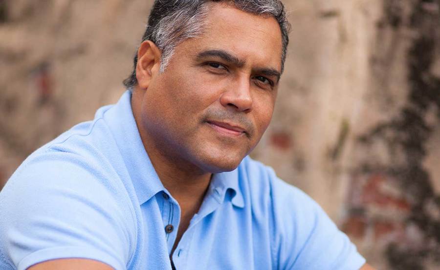 A smiling middle-aged Hispanic man represents the full life that can be led after rectal cancer treatment.