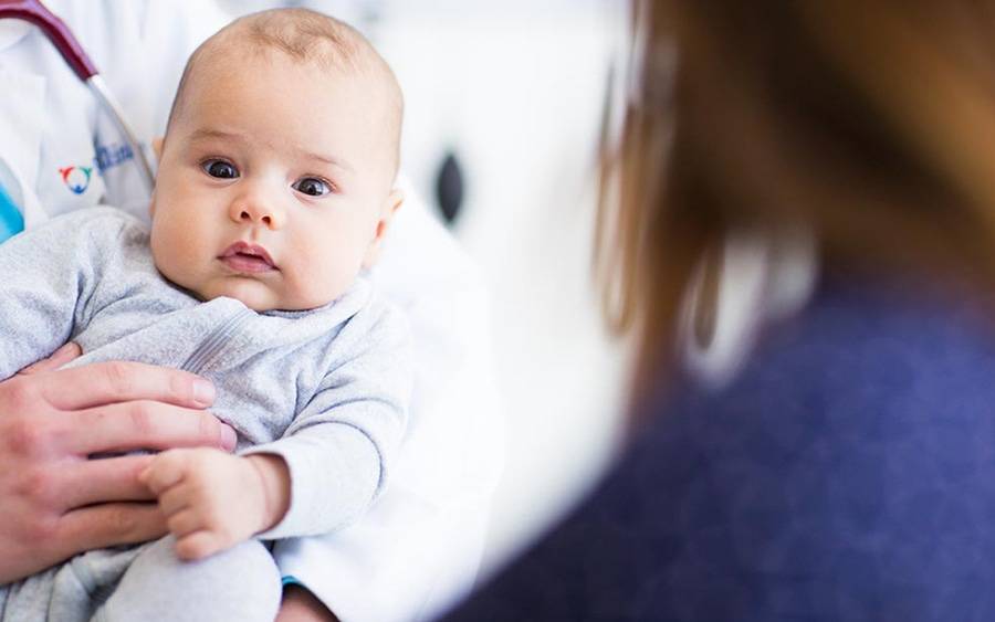 A health care provider cradles an infant, illustrating the range of patients treated at Scripps HealthExpress Rancho Bernardo, a walk-in clinic offering care for minor illness and injuries to pediatric patients from 3 months to 17 years.