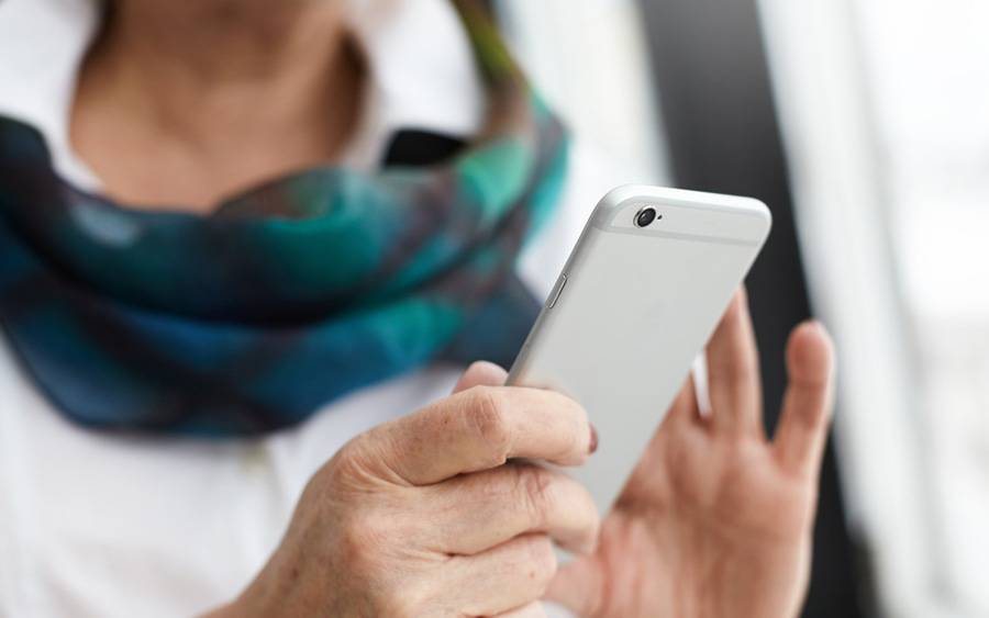 A middle age woman using her phone, represents the many Scripps patients that stay connected by following our social channels.
