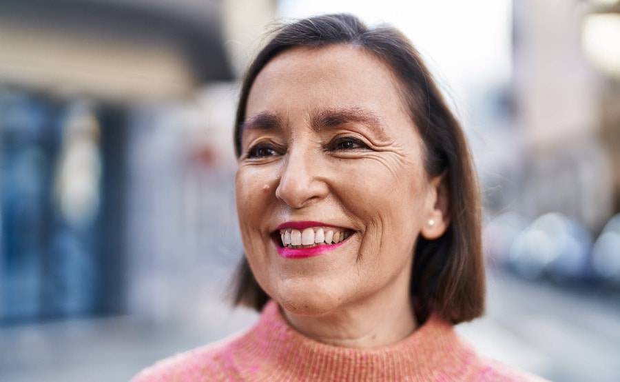 A smiling middle-aged woman represents a healthier life with treatment for venous disease or varicose veins.