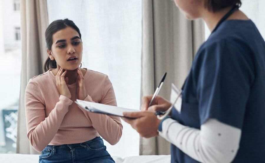 A young woman discussing her health concerns with a provider in a clinic, illustrating an appointment at a Scripps HealthExpress location.