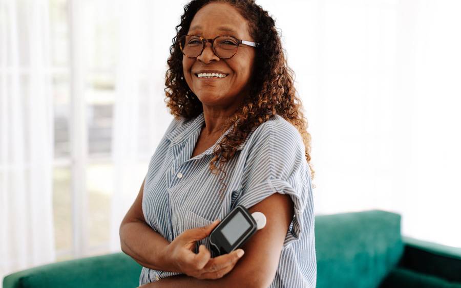 An African American woman with diabetes monitors her blood glucose levels.